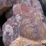 Крупный красный валун из диабаза для декоративного оформления участка